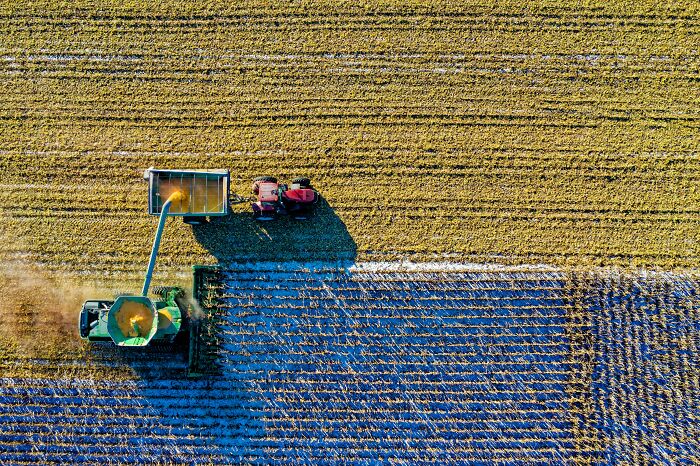 Aerial view of farm machinery harvesting a field, illustrating themes from unfortunate lottery money stories.