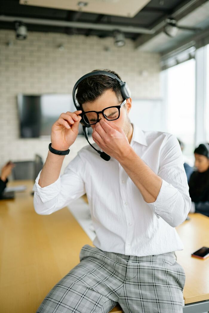 First responder wearing headset and glasses, showing a stressed reaction while handling a difficult emergency call.