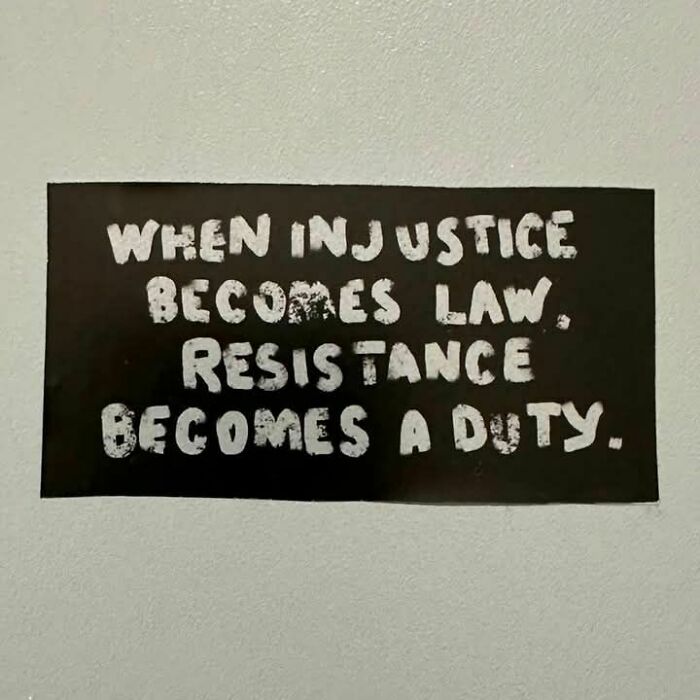 Cartel negro con texto en inglés sobre la resistencia contra la injusticia, ilustrando momentos de hartura contra el capitalismo.