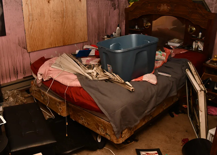 Disturbing room scene with cluttered bed and damaged items in a horror house.