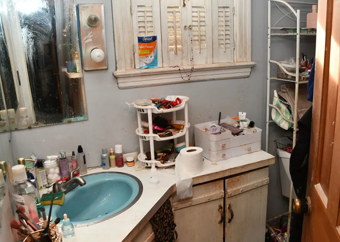 Cluttered bathroom in horror house linked to "evil" mom case, showing sink and toiletries in disarray.
