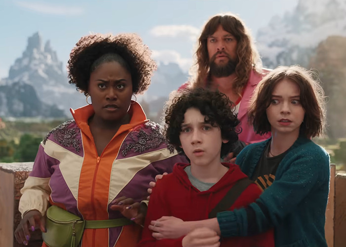 Four actors in a dramatic scene from "A Minecraft Movie," with mountains in the background. Four actors in a dramatic scene from "A Minecraft Movie," with mountains in the background.