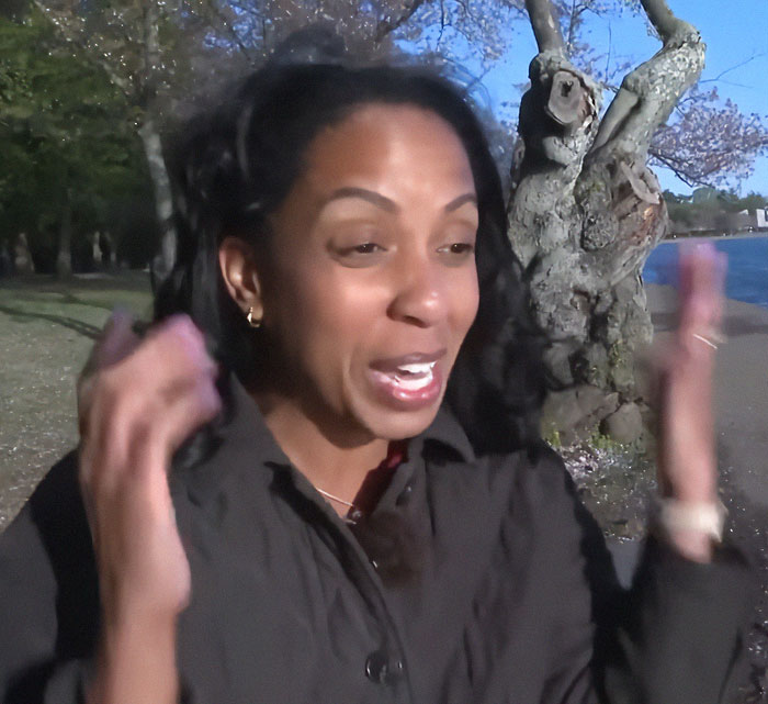 A surprised woman reacts joyfully outdoors during a kids' photo shoot moment with Barack Obama.