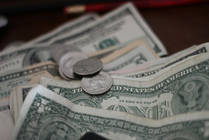 Close-up of cash and coins on a table, representing financial aspects of quality of life improvement.