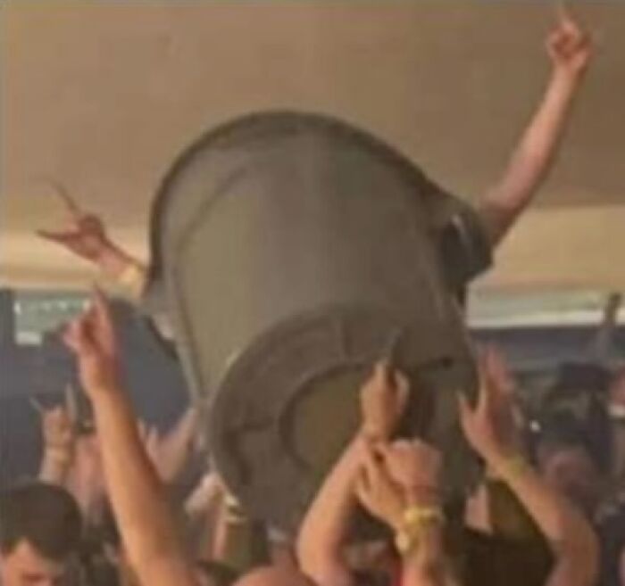 People at a party lifting a trash can above their heads, creating a funny scene for an Instagram account sharing random images.