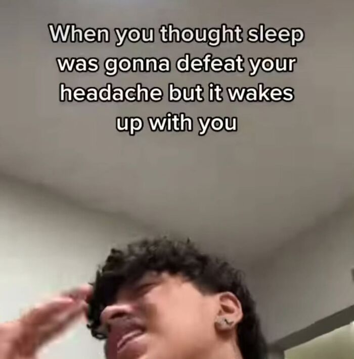 Person holding head in frustration with text about waking up with a headache. Funny and painfully relatable meme.
