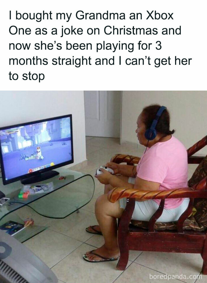 Grandma playing Xbox intently, wearing headphones, sitting near TV. Relatable meme humor evokes laughter and smiles.