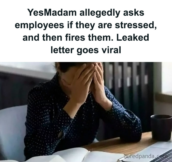 Stressed employee with head in hands at a desk, related to unbelievable fake headlines.