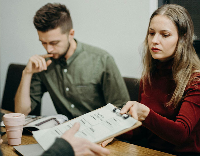 Two people at a table reviewing financial documents, capturing a moment of recession-related discussion and decision-making.