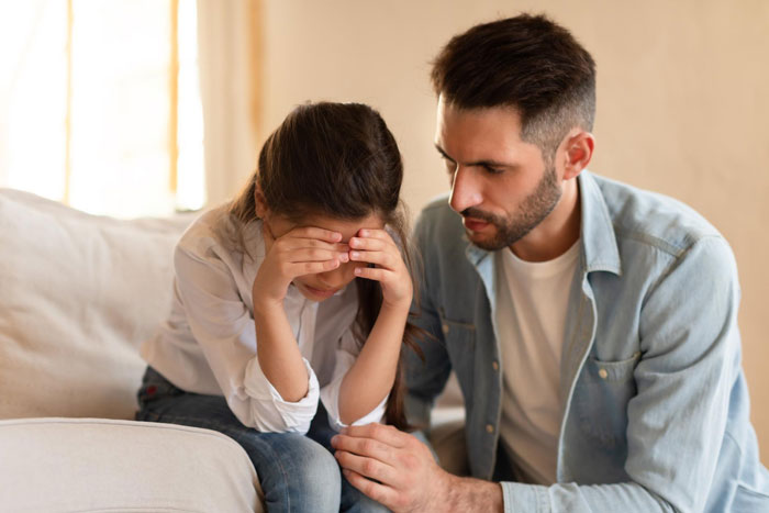 Father comforting his upset daughter with leukemia as she watches for bears every night, showing care and concern at home. Father comforting his upset daughter with leukemia as she watches for bears every night, showing care and concern at home.