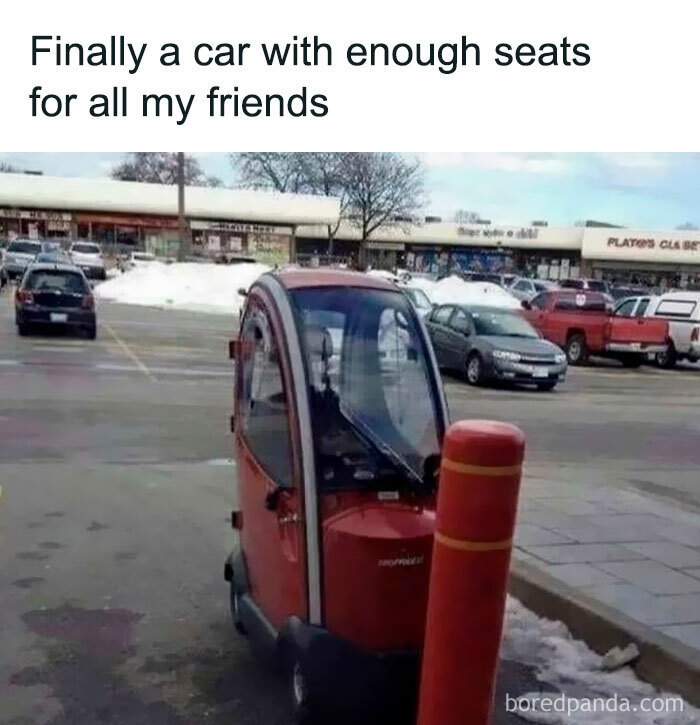 Small red car with one seat in parking lot, humorously depicting introverts and social exhaustion.