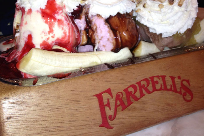 Ice cream sundae with banana and whipped cream in Farrell's wooden bowl, a nostalgic restaurant memory.