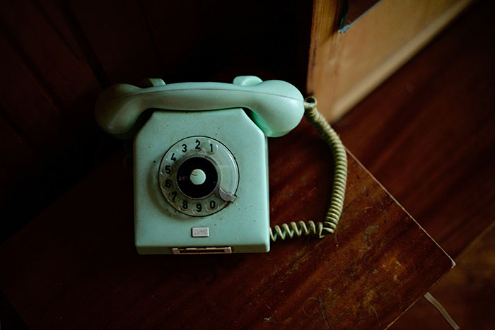 Vintage rotary phone on a wooden table, evoking memories from restaurants that no longer exist.