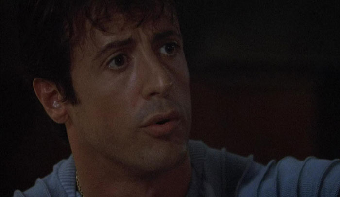 Actor showing intense expression in a dimly lit scene, demonstrating dedication to difficult roles in his performance.