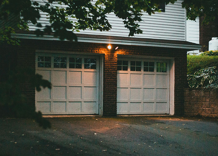 Well-lit garage with closed doors at dusk, illustrating crime reporter safety tips.