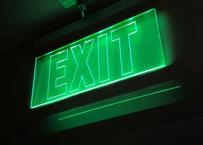 Glowing green exit sign highlighting safety tips from a crime reporter.