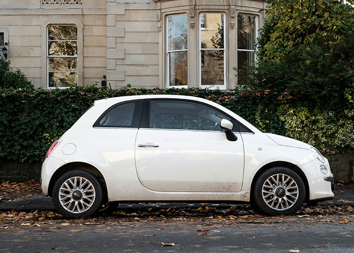 White car parked on a residential street, crime safety tips context.
