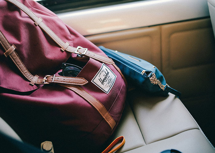 Bag and sunglasses on car seat, emphasizing crime reporter's safety tips.
