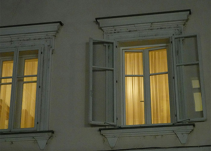 Illuminated window at night, highlighting home safety aspect discussed by a crime reporter.