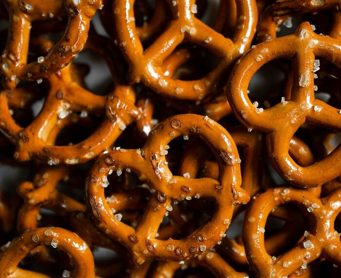 Close-up of salty pretzels, each with a distinct knot shape, detailed with salt crystals.