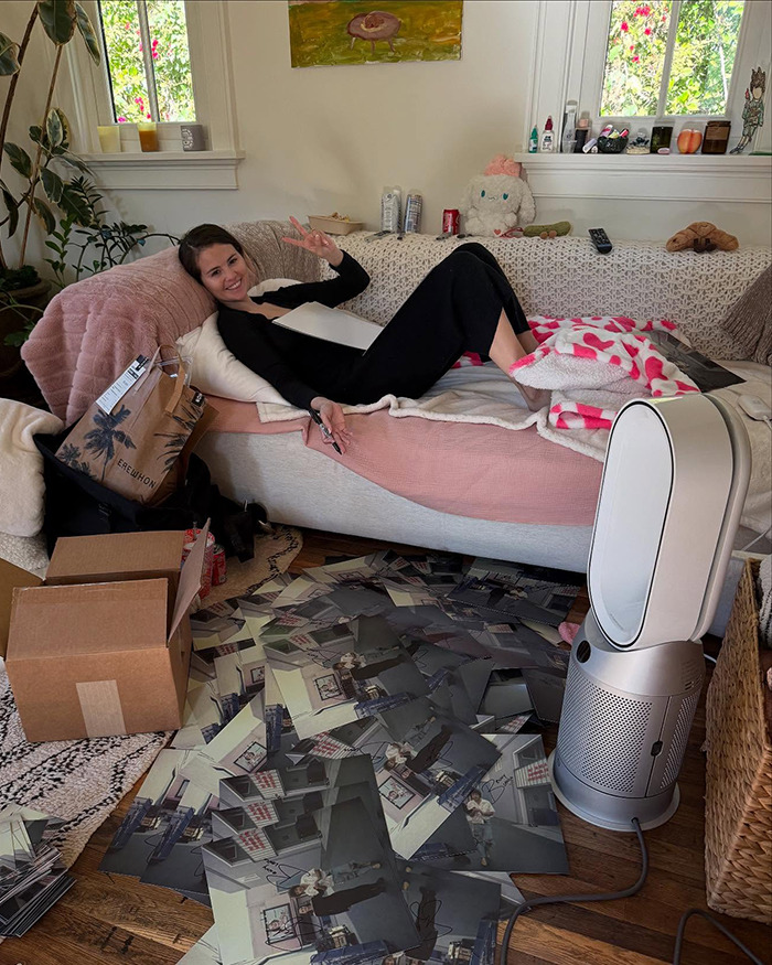 Woman relaxing on a sofa with photos on the floor, offering a glimpse into her intimate life.