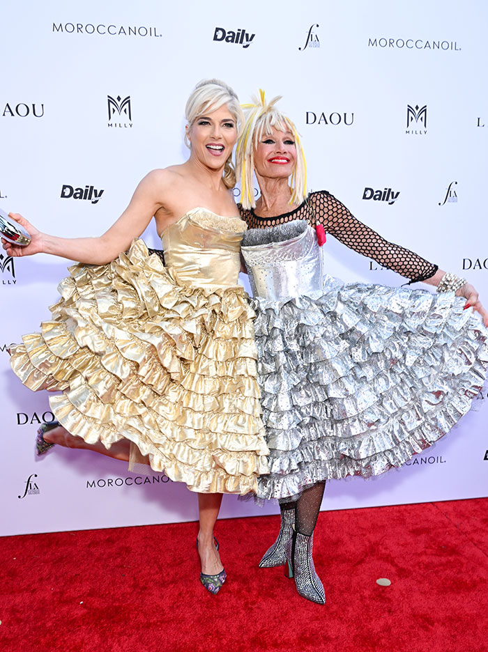 Two women in ruffled dresses on the red carpet, expressing amazing personality at a fashion event. Two women in ruffled dresses on the red carpet, expressing amazing personality at a fashion event.