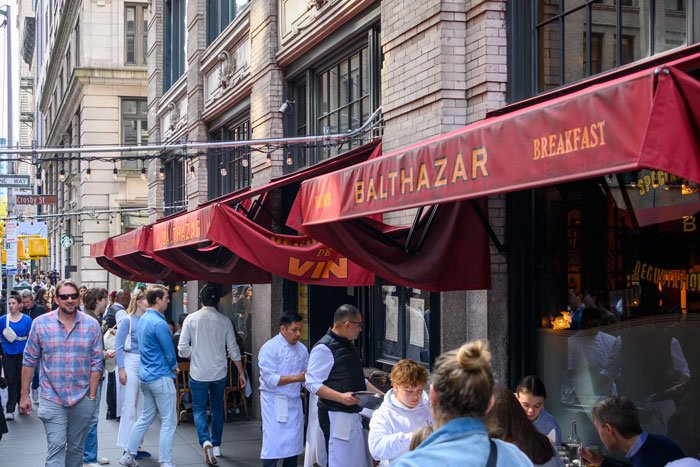 Balthazar restaurant in NYC bustling with people, linked to punk rock legend news.