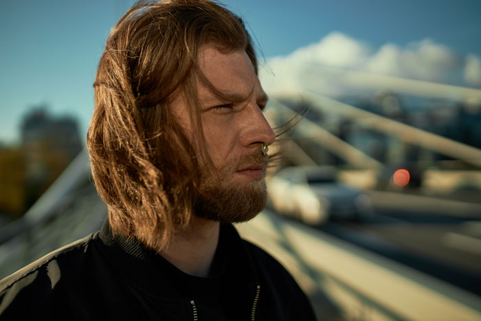 Man with nose ring and long hair standing on a bridge, exemplifying a complex relationship decision. Man with nose ring and long hair standing on a bridge, exemplifying a complex relationship decision.