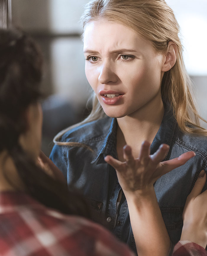 Two women in a serious conversation with one quickly shutting down the other after trying to change tradition. Two women in a serious conversation with one quickly shutting down the other after trying to change tradition.