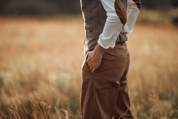 Person standing in a field with hands in pockets, showcasing a legal activity that gives off psychopath vibes.