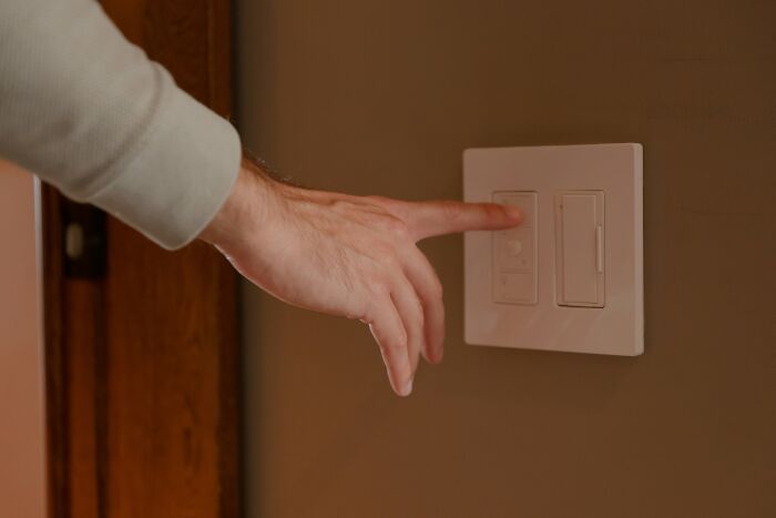 Hand reaching for light switch, illustrating legal yet unsettling behaviors.