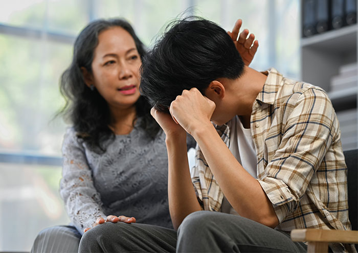 Mother talks to a stressed teen boy in a plaid shirt, emphasizing the role of a man of the house. Mother talks to a stressed teen boy in a plaid shirt, emphasizing the role of a man of the house.