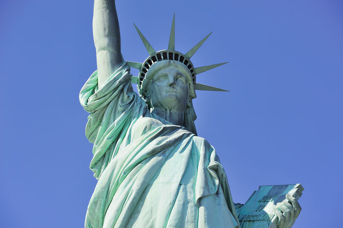 Statue of Liberty up close against a clear blue sky, portraying a symbol of freedom.