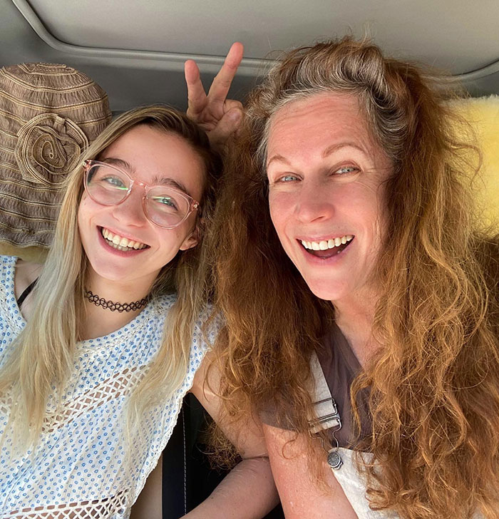 Two smiling women in a car, one making a peace sign, associated with the former child star mystery.