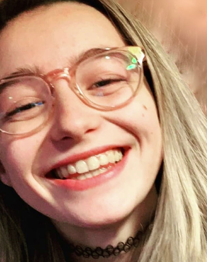 Smiling former child star Sophie Nyweide, wearing glasses, sparking speculation after her passing.