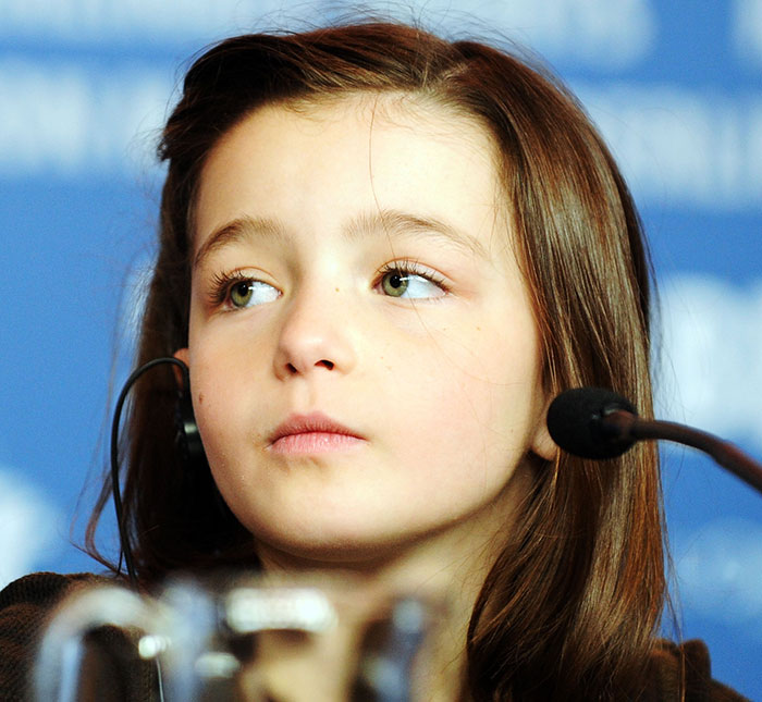 Former child star Sophie Nyweide during a press event, microphone beside her, sparking speculation about her career.