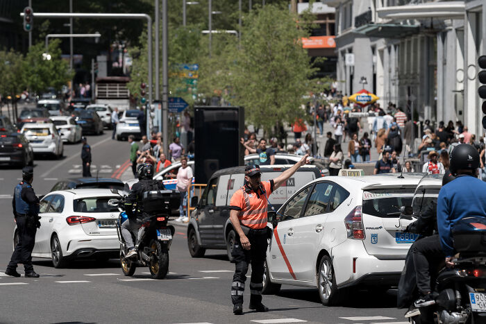 Police directing traffic in a busy European street during a major blackout affecting millions and paralyzing activities.