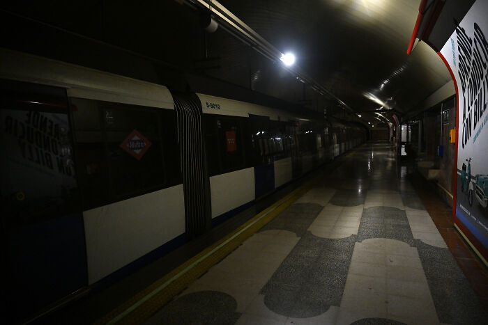 Dark underground train station platform with minimal lighting during a major blackout affecting millions in Europe.