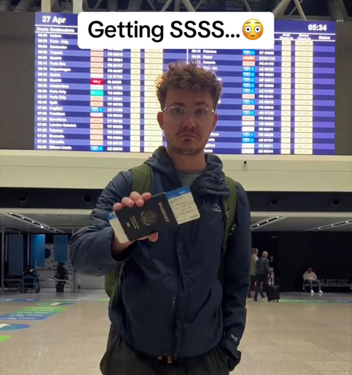 Traveler holding a passport with SSSS code in an airport, indicating potential flight issues. Traveler holding a passport with SSSS code in an airport, indicating potential flight issues.