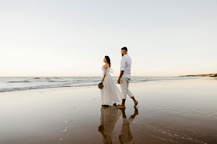A couple walking on a serene beach, symbolizing a story of karma and life reflections.