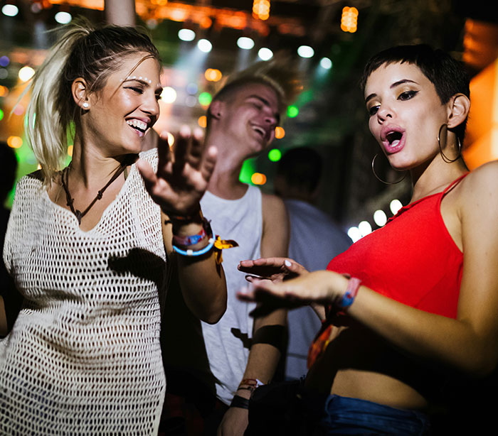 People dancing energetically at a party, reflecting casual admissions atmosphere.