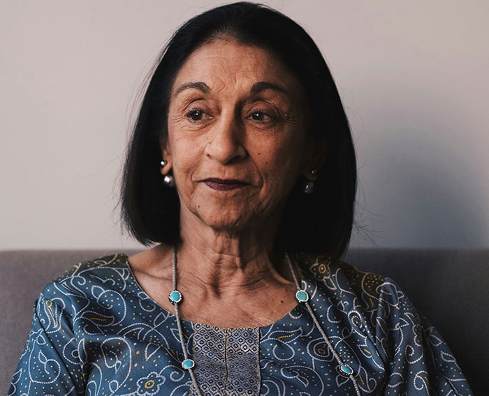 Elderly woman in patterned attire sitting on a couch, symbolizing casual admissions and surprising personal stories.