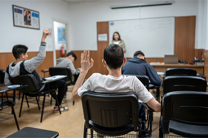 Students in a classroom raising their hands, illustrating coincidences in education settings.