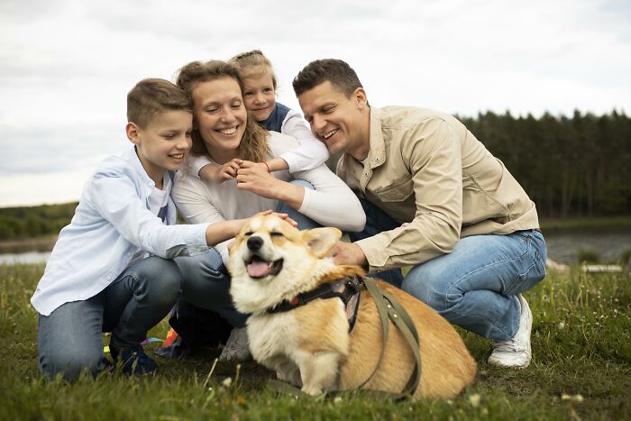 Family enjoying time outdoors with their dog by the lake, symbolizing unity in hard times with partners.