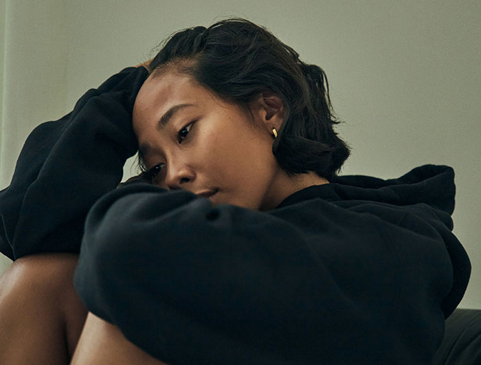 Person sitting thoughtfully, wearing a dark hoodie, contemplating schedule for babysitting nephews. Person sitting thoughtfully, wearing a dark hoodie, contemplating schedule for babysitting nephews.