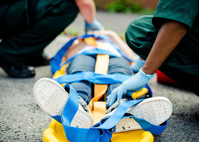 Person being attended to by medics outdoors, showcasing consequences of ignoring advice.