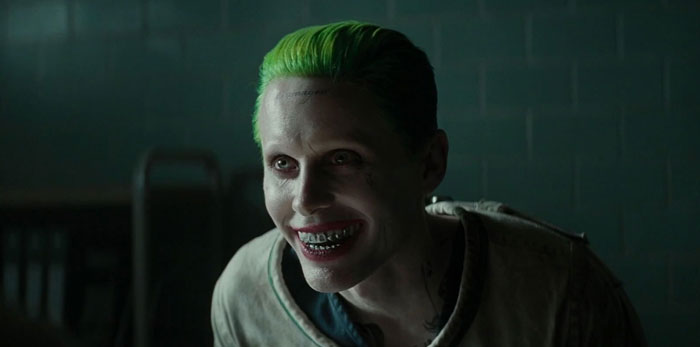 Actor with green hair and metallic teeth portraying a difficult role, demonstrating commitment and transformation for the character.