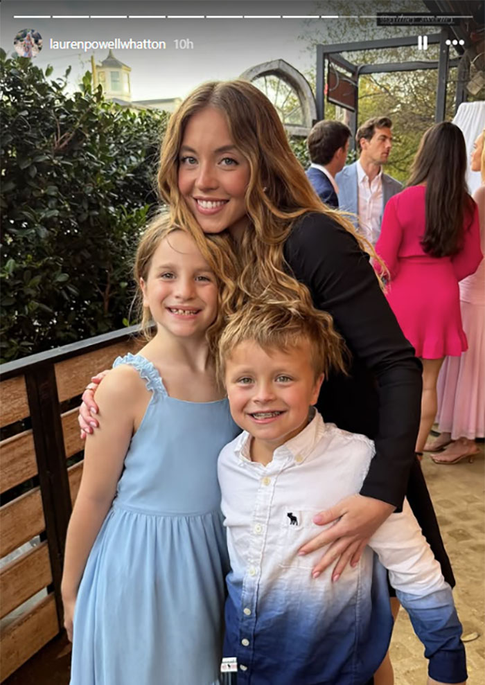 Sydney Sweeney smiling with children at Glen Powell's sister's wedding.