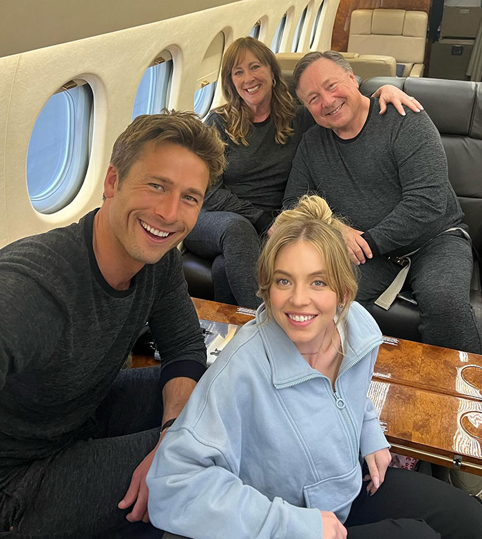 Sydney Sweeney with friends on a plane, causing fan debate about her outfit choice.