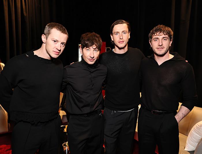 Actors posing for a Beatles biopic casting, sparking mixed reactions among fans.